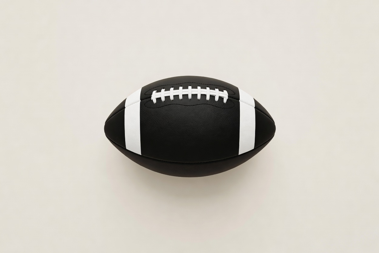Soft-lit 3D render of a classic black and white football resting on a plain cream surface